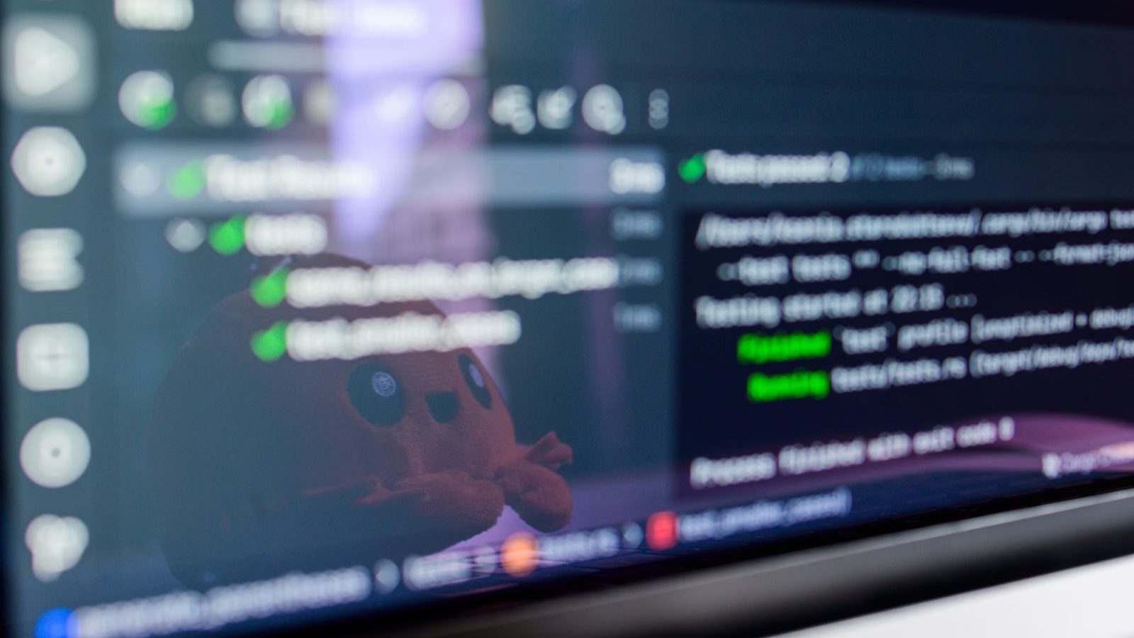 Ekran monitora ustawiony pod kątem, na nim ciemny edytor kodu z zielonymi wynikami testów