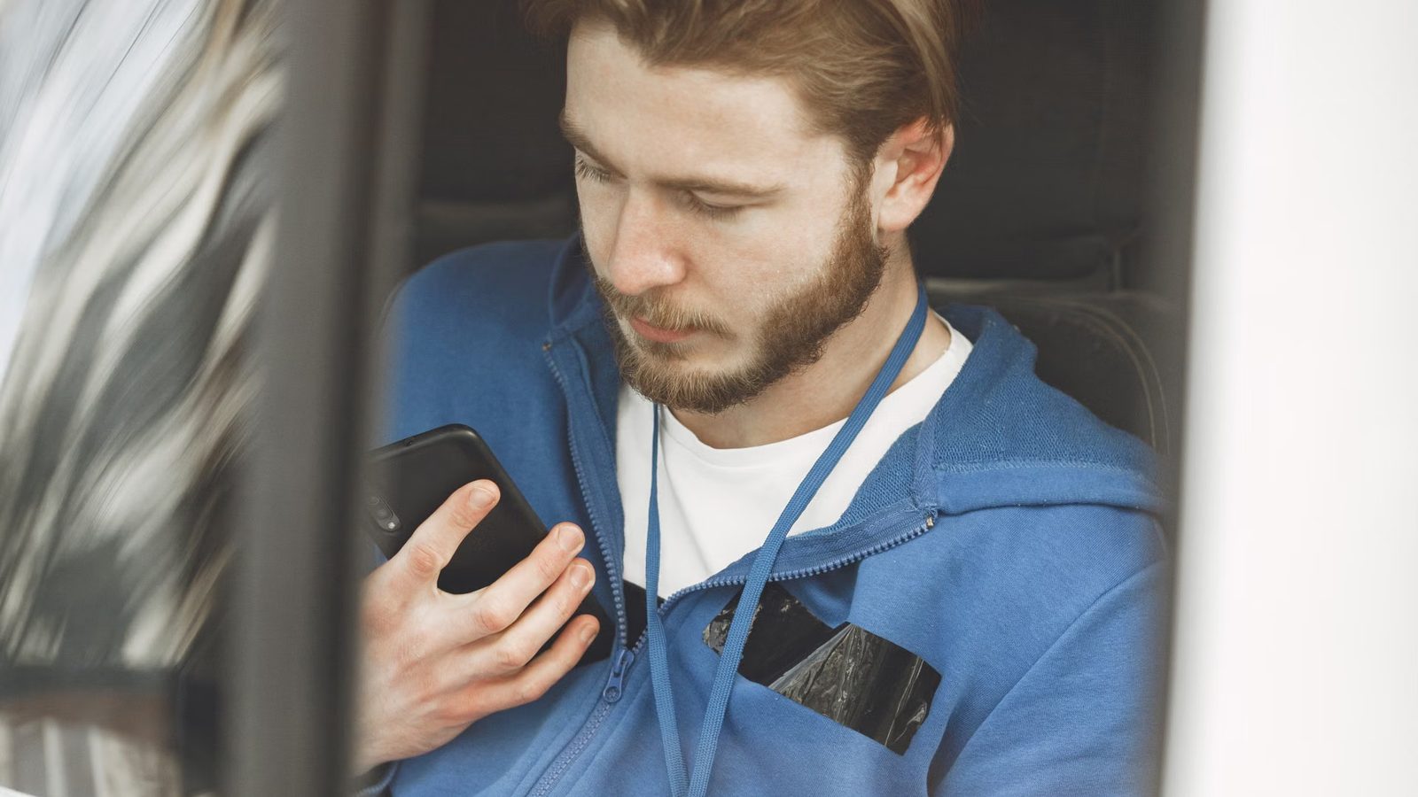 Kierowca z mapą w telefonie na siedzeniu