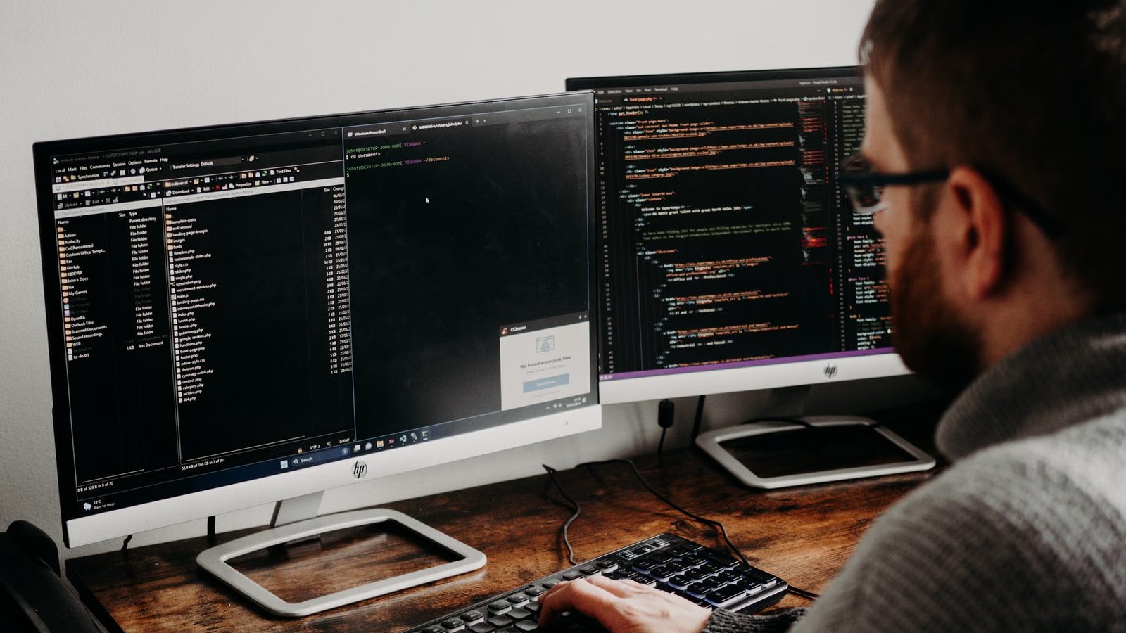 Programista przy dwóch monitorach z kodem
