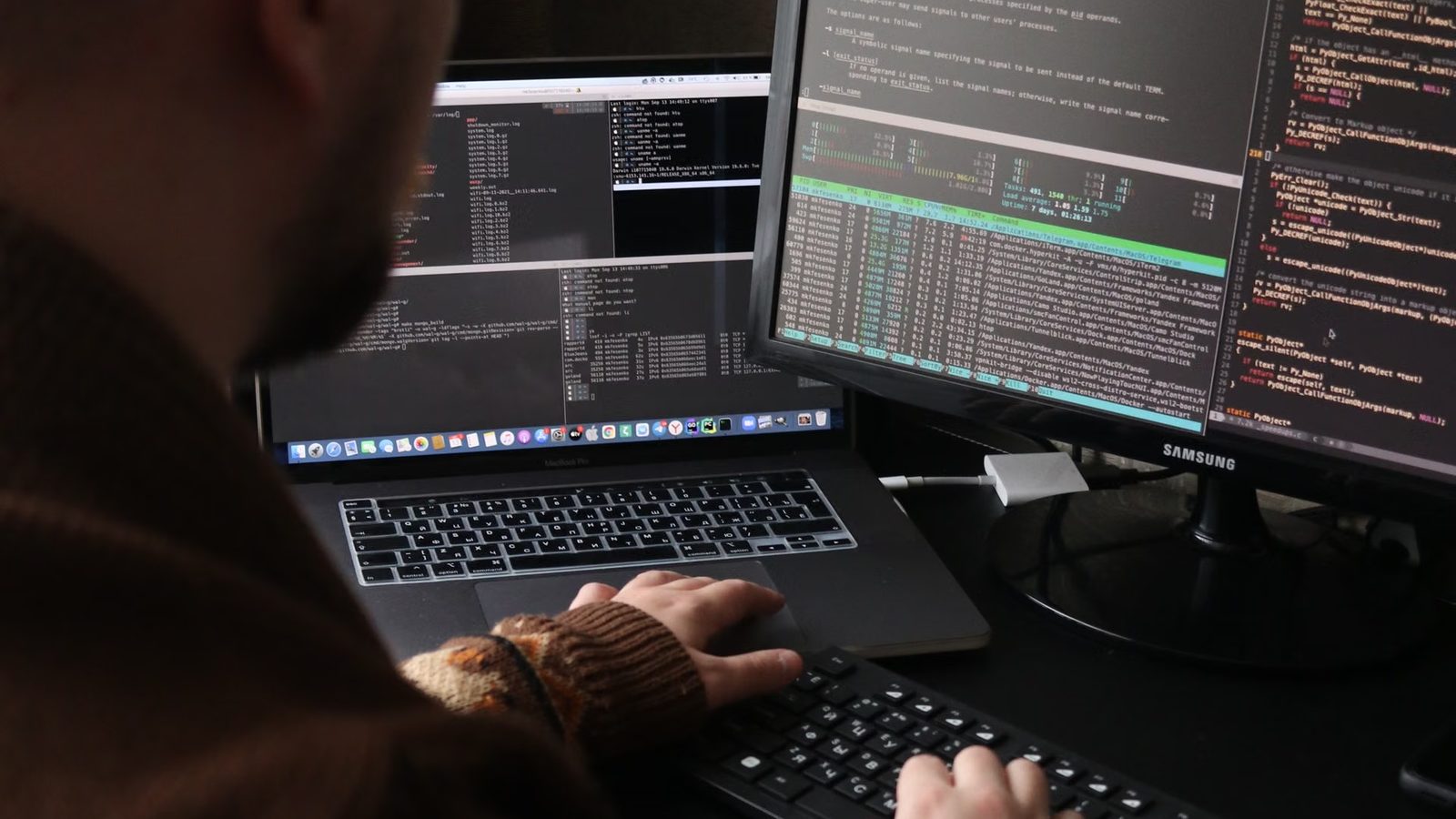 Programista przy dwóch monitorach z kodem