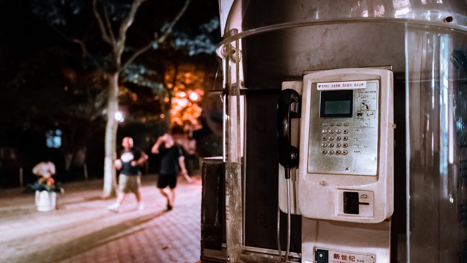 Przechodnie z telefonami na wieczornej ulicy