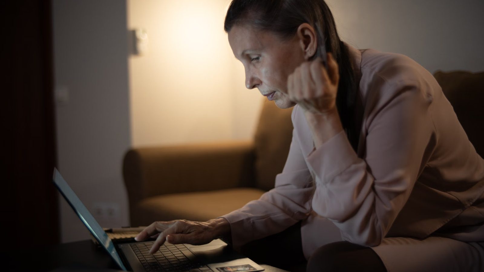 Osoba przegląda strony na laptopie wieczorem