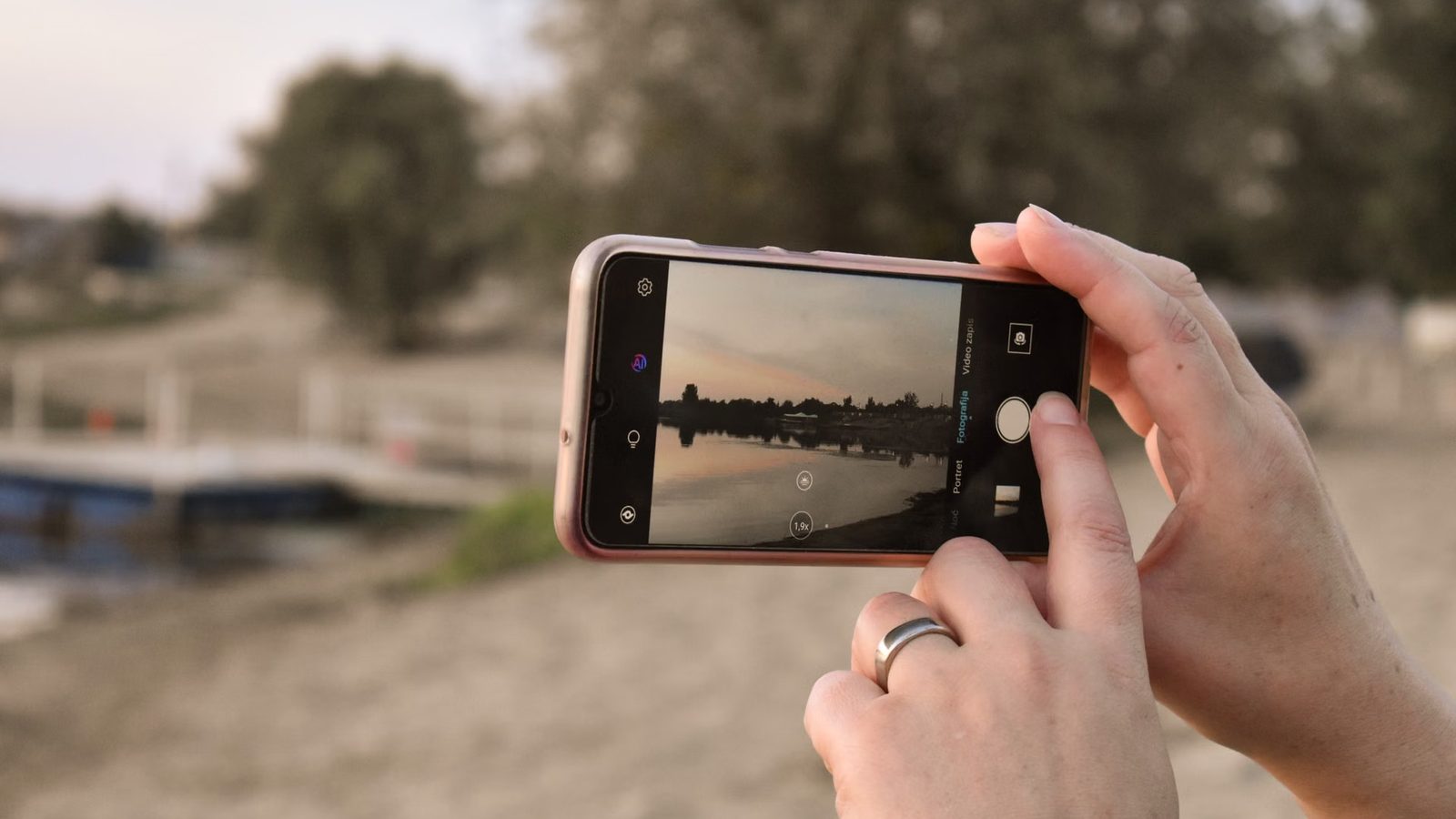Zdjęcie zachodu słońca nad jeziorem telefonem