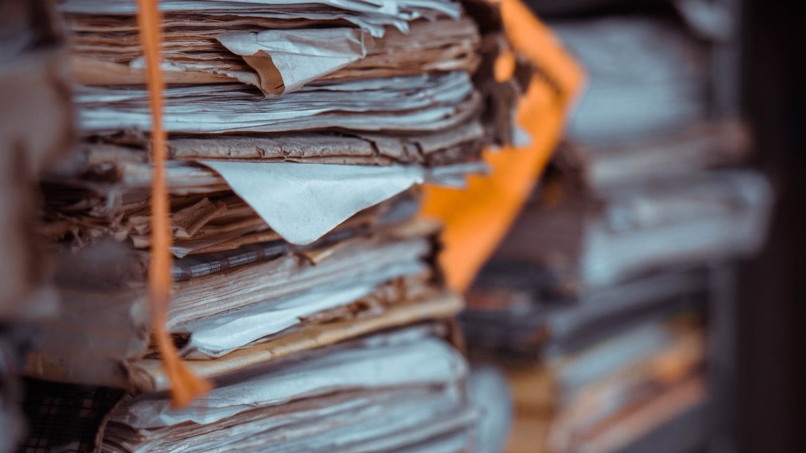 Stosy starych papierów i teczek przewiązanych sznurkiem