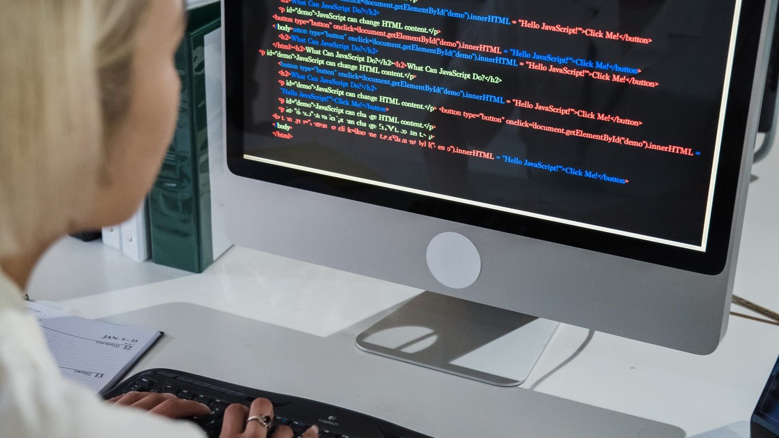 Programistka przy monitorze z kodem strony