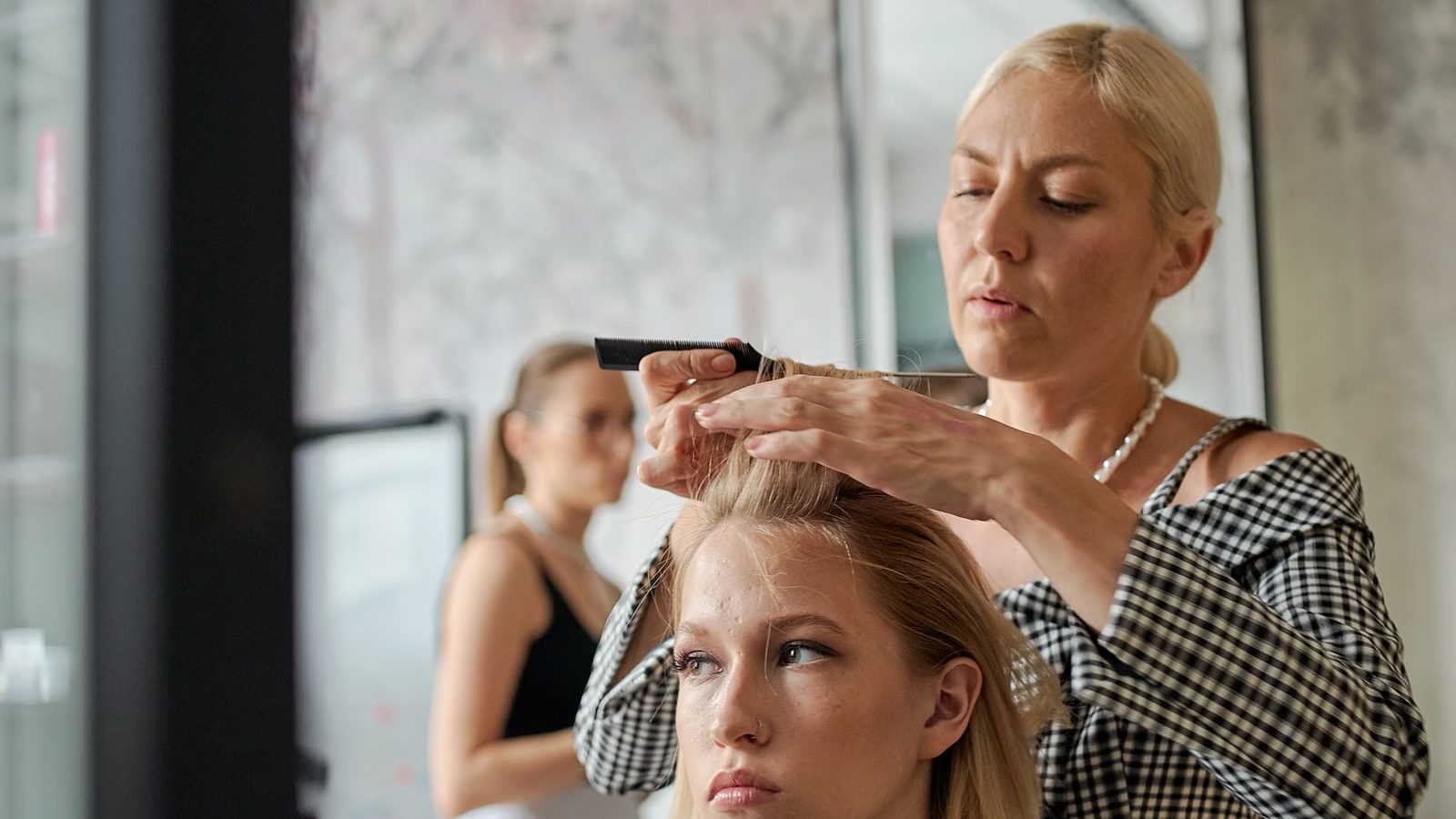 Fryzjer przy pracy z klientem w salonie