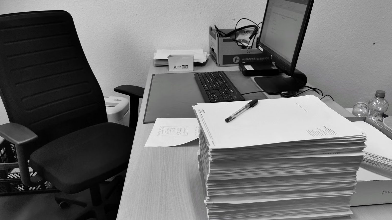 Biurko z komputerem i papierami w warsztacie