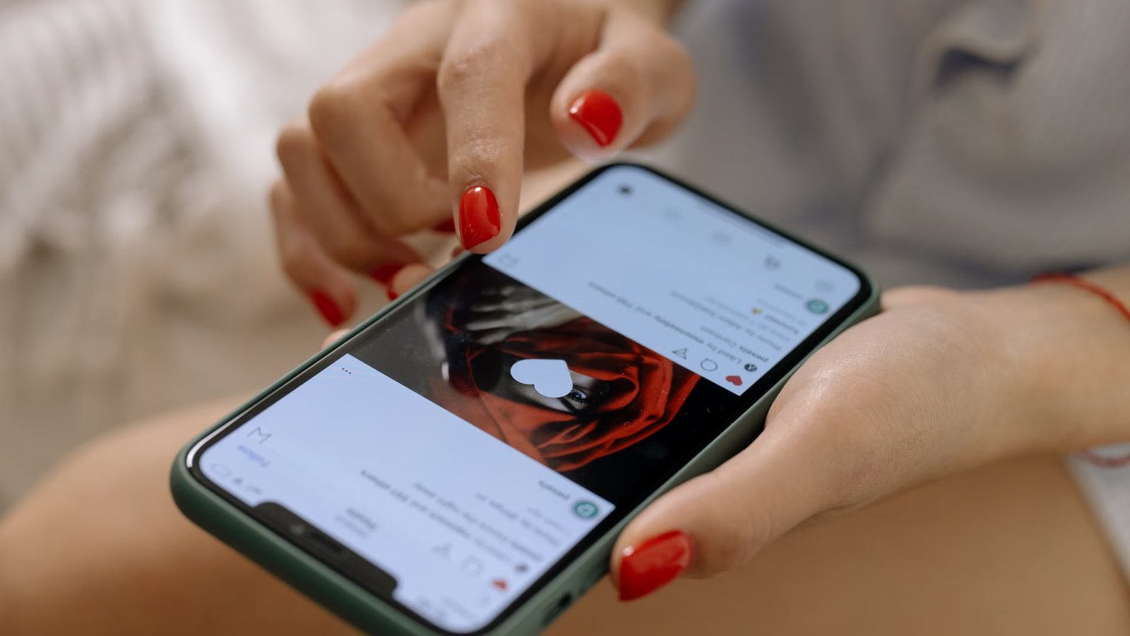 Dłoń klika serce pod zdjęciem w aplikacji społecznościowej na telefonie