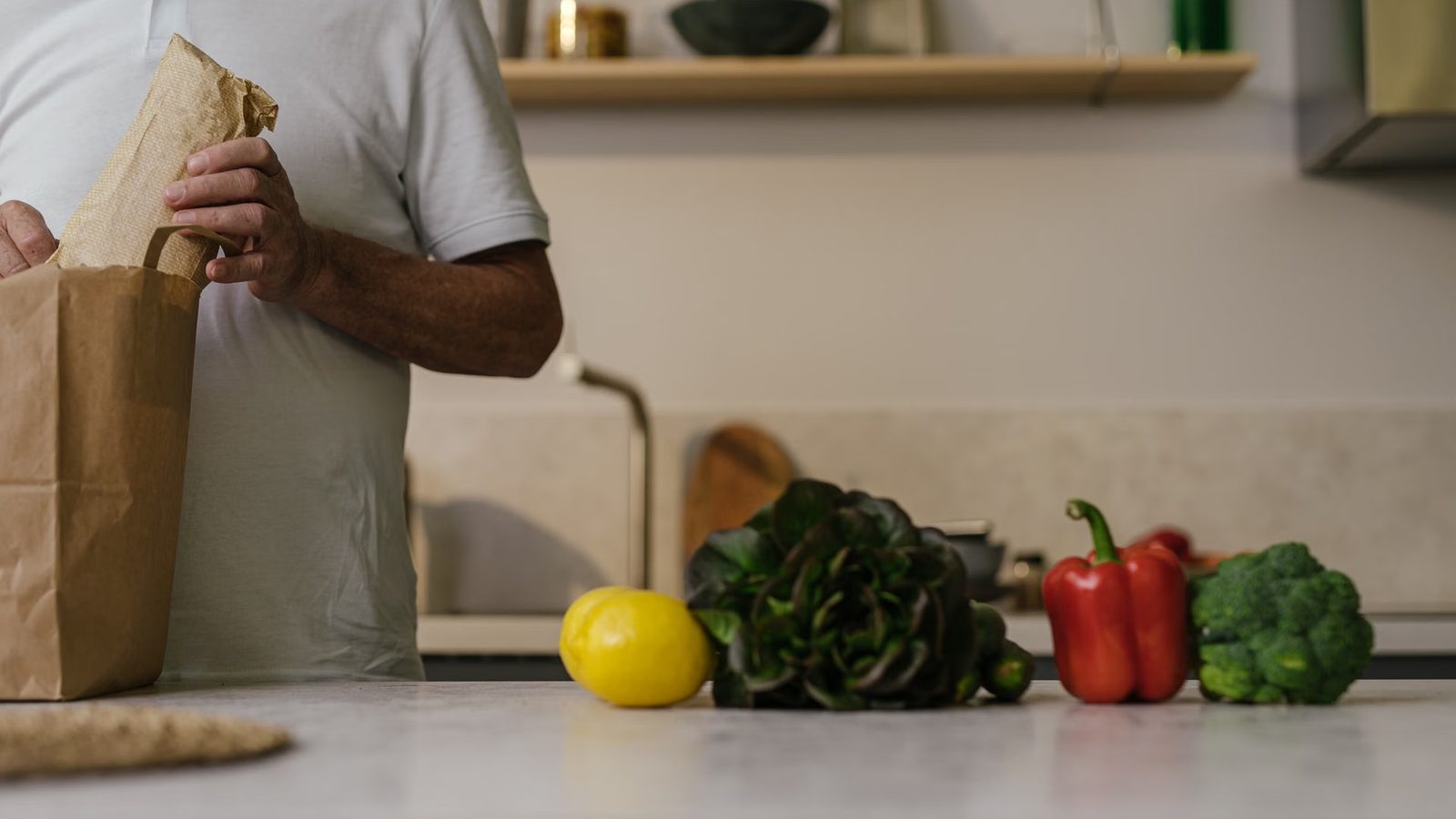 Mężczyzna z torbą zakupów w kuchni