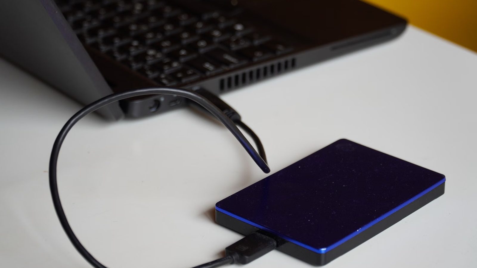 Dysk zewnętrzny podłączony kablem do laptopa