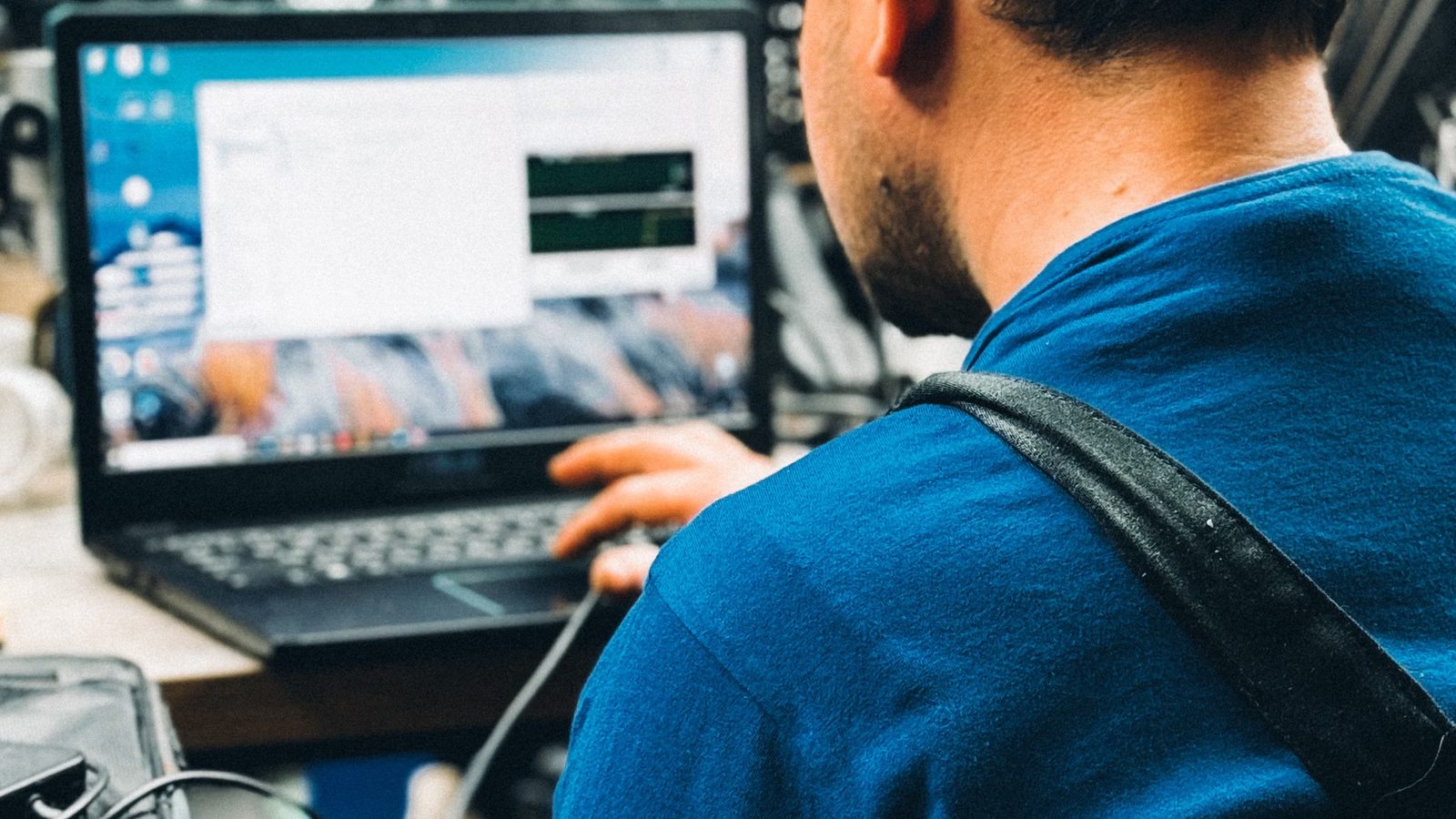 Mężczyzna przy laptopie w warsztacie
