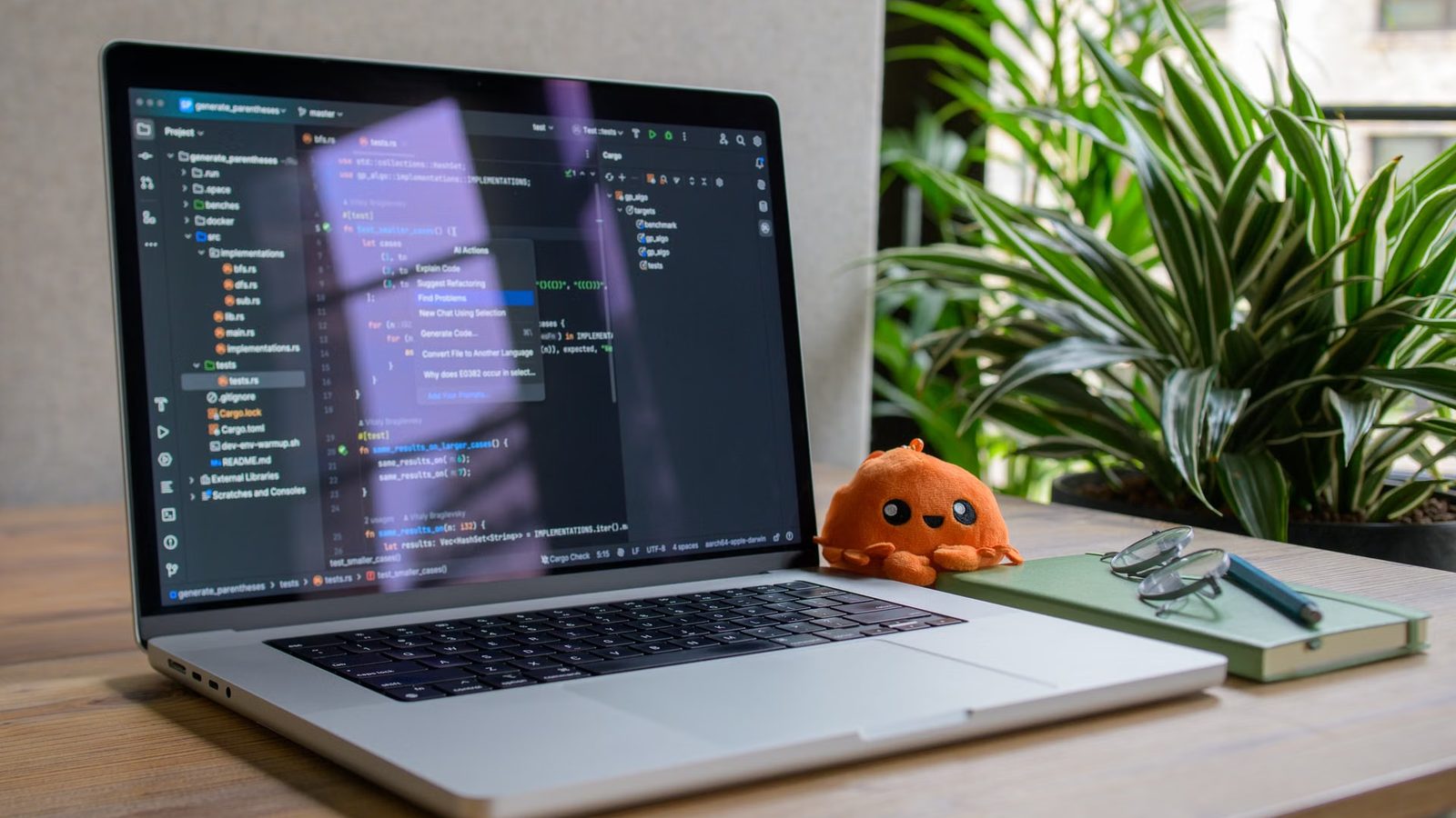 Laptop z kodem na biurku wśród roślin