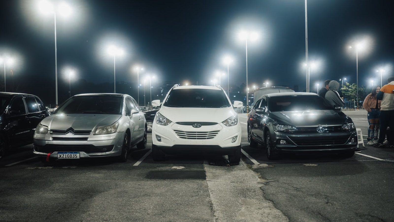 Zaparkowane samochody na oświetlonym parkingu