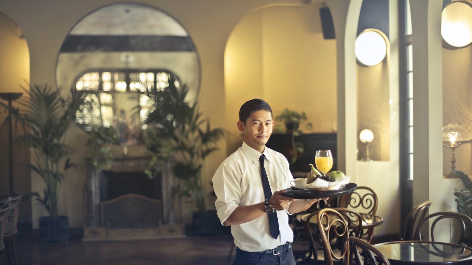 Kelner obsługuje gości na tarasie restauracji