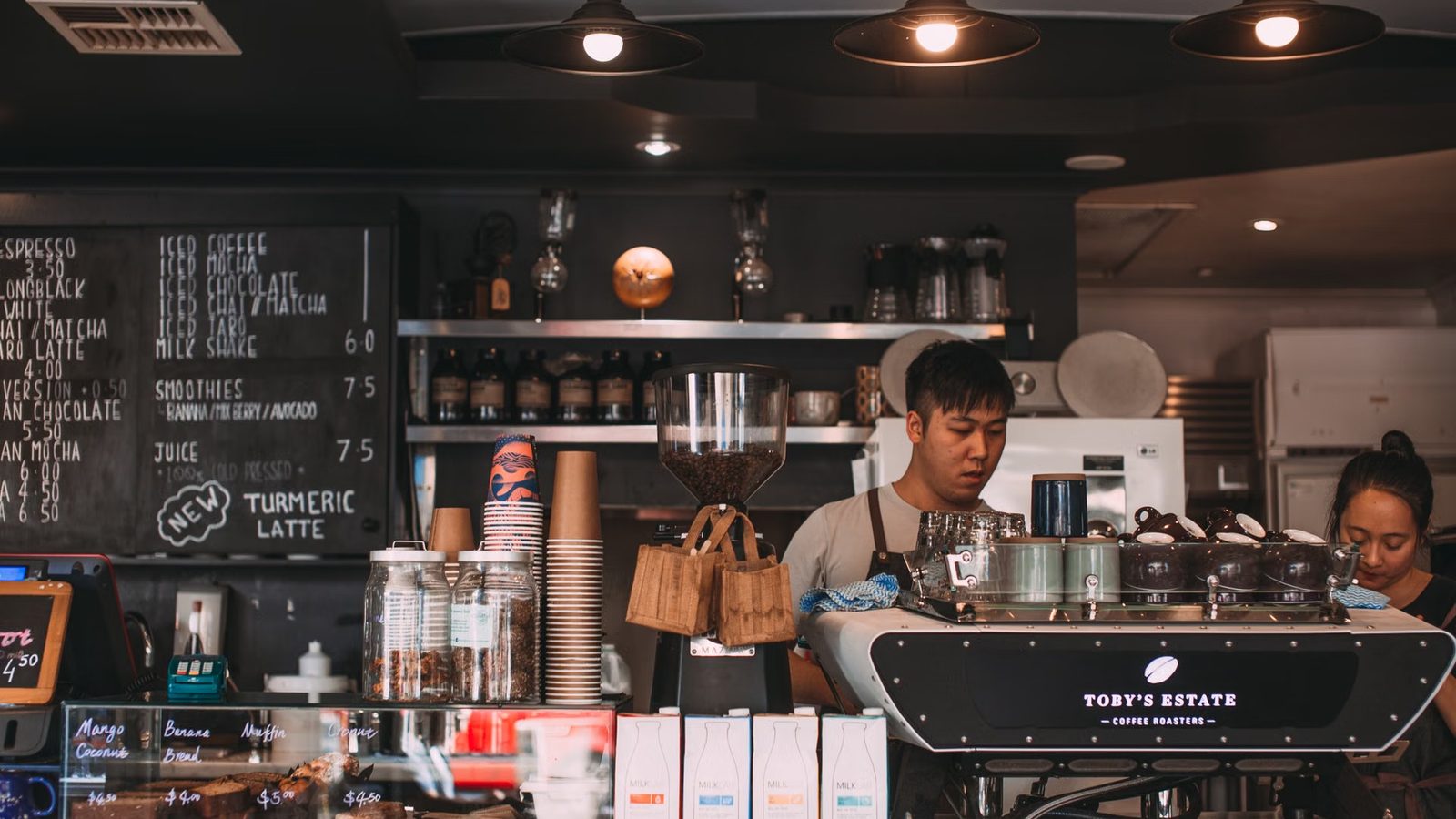 Barista fotografuje kawę przy ladzie
