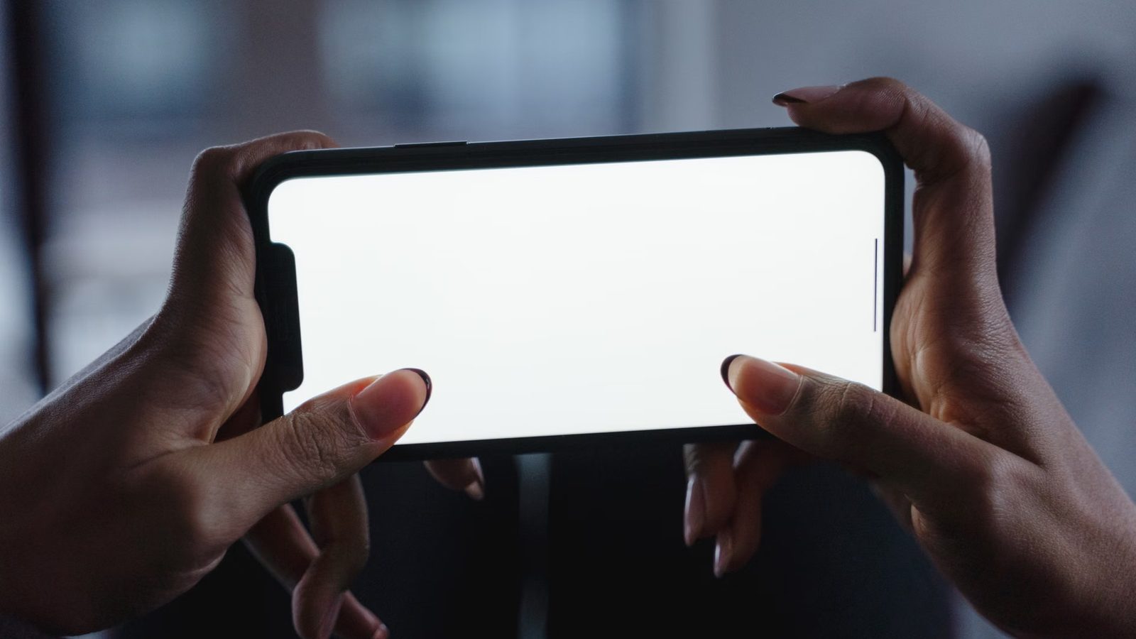 Dłonie trzymające telefon z wahaniem