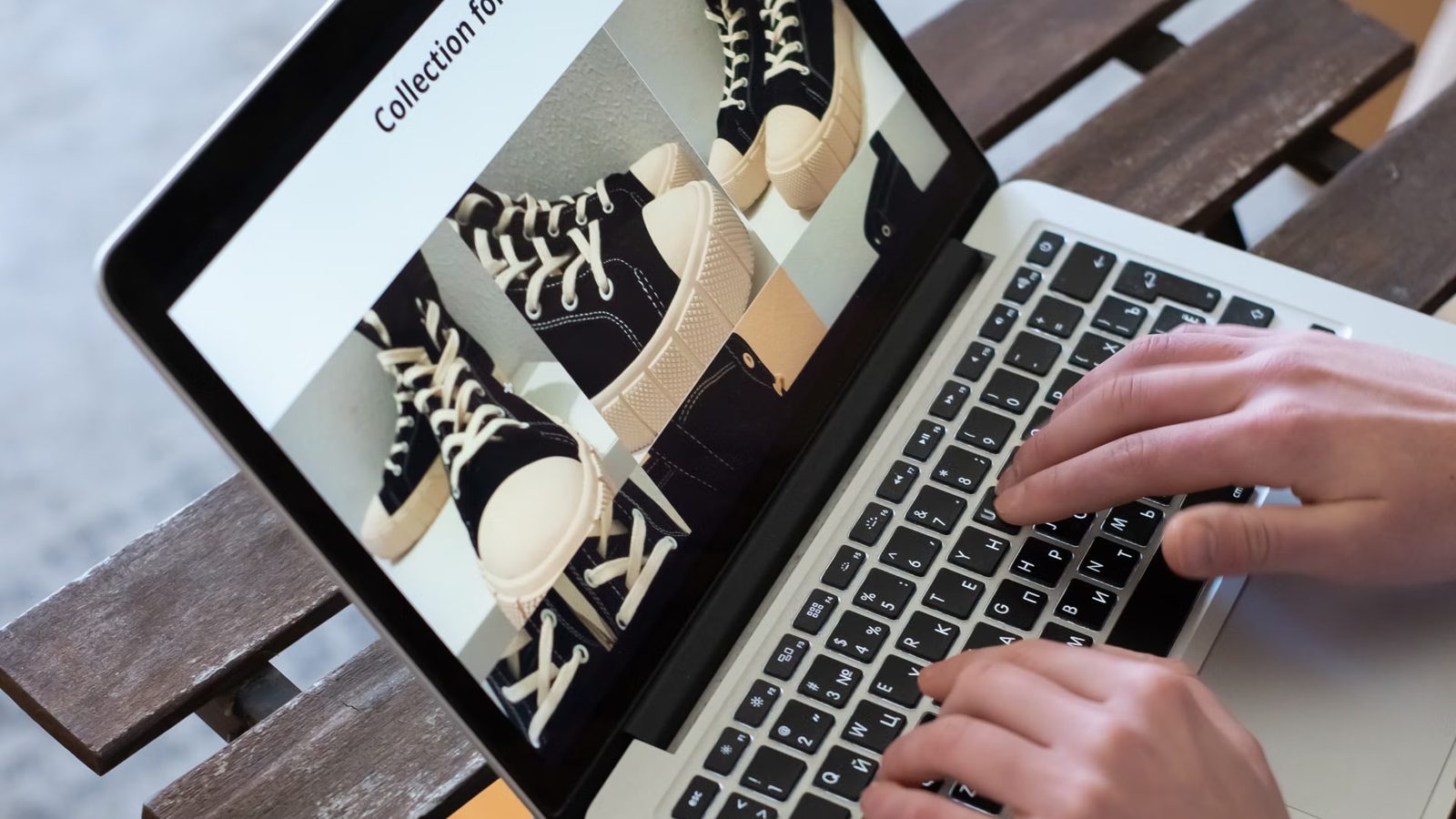 Ręce na klawiaturze laptopa, na ekranie zdjęcia butów w sklepie internetowym