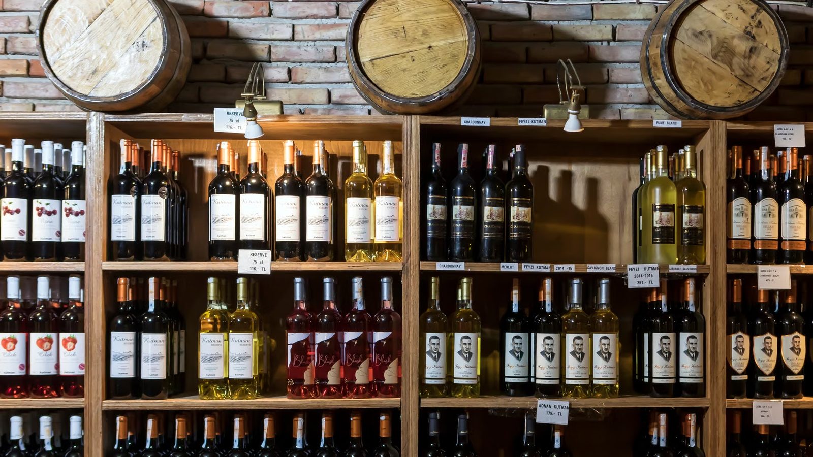 Butelki wina na drewnianej półce w piwnicy