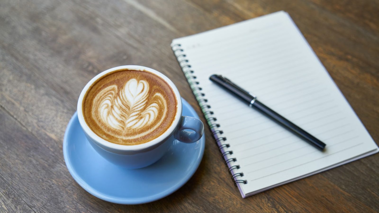 Notes, długopis i kawa na stole