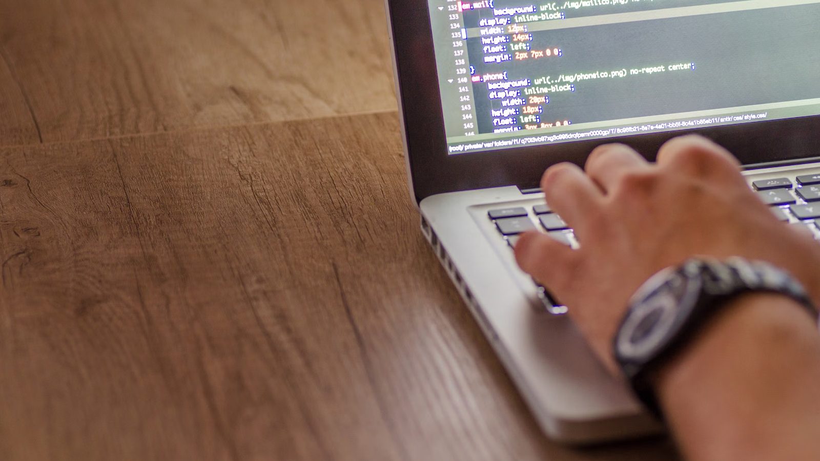 Programista piszący kod na laptopie